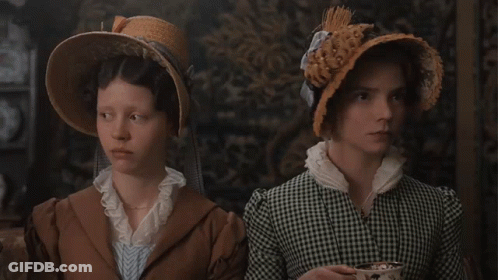 Two Women Standing Next To Each Other Wearing Hats And Dresses GIF