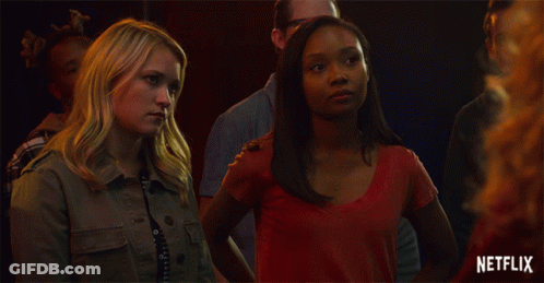 Two Women Standing Next To Each Other With A Netflix Logo In The Background GIF