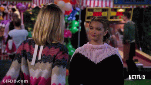 Two Women Standing Next To Netflix Logo GIF
