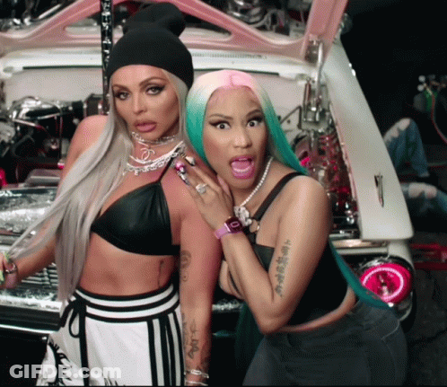 Two Women Standing Next To Each Other With One Having A Tattoo On Her Arm GIF