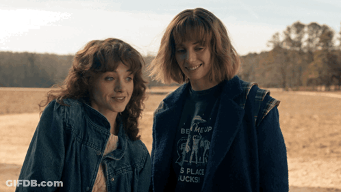 Two Women Standing Next To Each Other With One Wearing A Shirt That Says Be Meup GIF