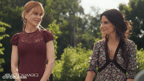 Two Women Standing Next To Each Other With #Practicalmagic2 On The Bottom Right GIF