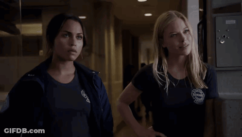 Two Women Standing Next To Each Other With Rescue Shirt GIF