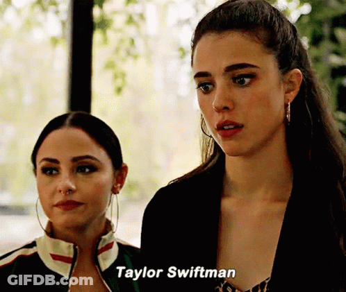 Two Women Standing Next To Each Other With Taylor Swiftman Written On The Bottom GIF