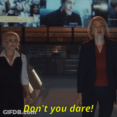 Two Women Standing Next To Each Other With The Words " Don 'T You Dare " In Yellow Letters GIF