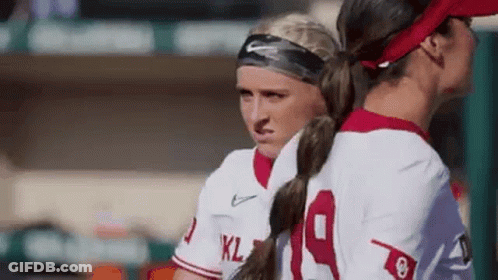 Two Women Standing On Baseball Field GIF