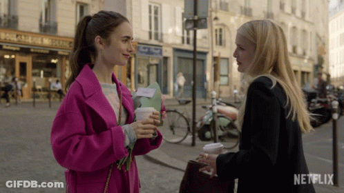 Two Women Standing On Street With Netflix Logo GIF