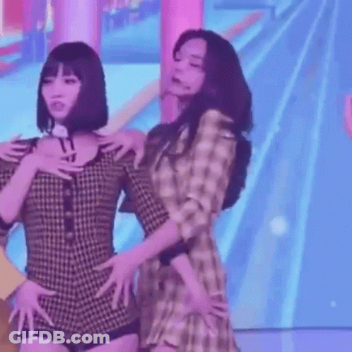 Two Women Standing Shoulder To Shoulder GIF