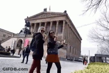 Two Women Taking Selfie In Front Of Building GIF