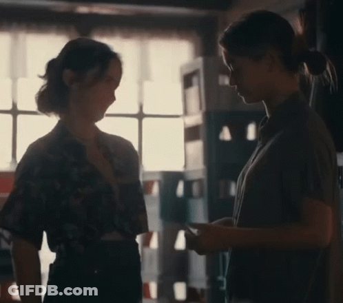 Two Women Talking In Dark Room GIF