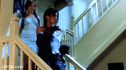 Two Women Walking Down A Set Of Stairs In A House GIF