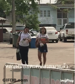 Two Women Walking Down Street GIF