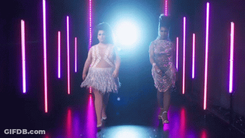 Two Women Walking In Dark Purple-Lit Room GIF