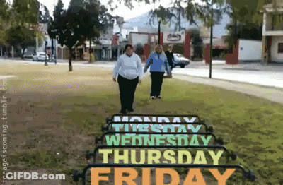 Two Women Walking In Front Of A Sign That Says Monday Through Friday GIF