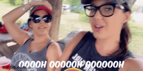 Two Women Wearing Glasses And Sunglasses Are Sitting Next To Each Other GIF