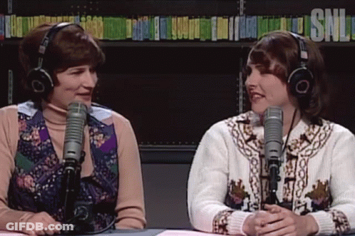 Two Women With Headphones In Front Of Microphones GIF
