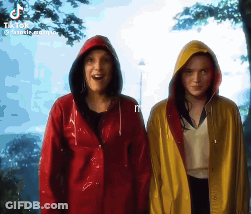 Two Women Wearing Red And Yellow Raincoats Are Standing Next To Each Other GIF