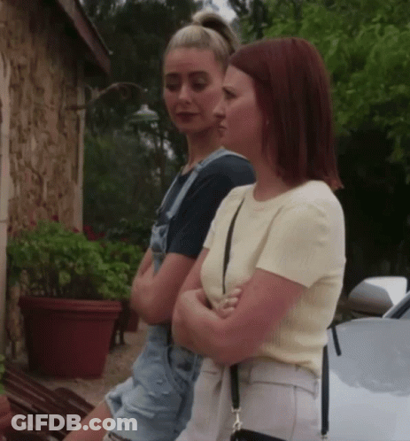 Two Women With Crossed Arms By White Car GIF