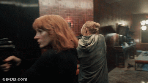 Two Women With Red Hair Are Standing In A Room GIF