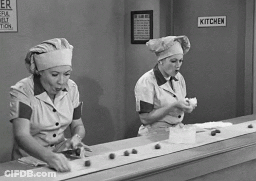 Two Women Working In Kitchen With Sign GIF