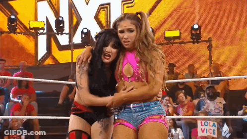 Two Women Wrestling In A Ring With A Sign That Says Lola Vice On It GIF