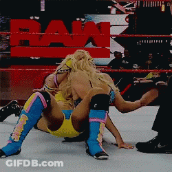 Two Women Wrestling In Ring With Raw Sign GIF