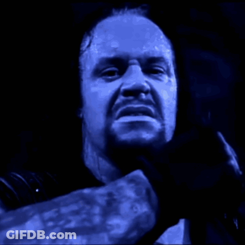 Two Wrestlers Are Fighting In A Wrestling Ring With A Crowd Watching In The Background GIF
