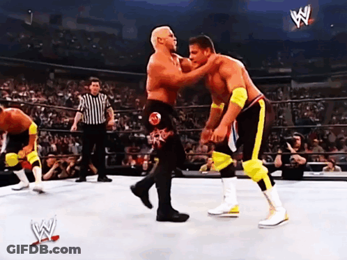 Two Wrestlers Are Fighting In A Wrestling Ring With A Referee In The Background And A Sign That Says W On It GIF