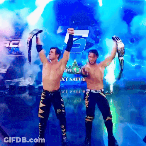 Two Wrestlers Are Holding Up Their Championship Belts In Front Of A Sign That Says Next Saturday GIF