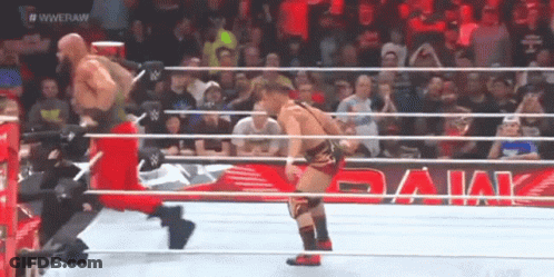 Two Wrestlers Are In A Wrestling Ring With A Banner That Says WWE Raw GIF