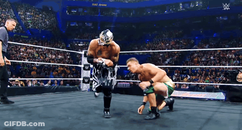 Two Wrestlers Are In A Wrestling Ring With A Sign That Says ' W ' On It GIF