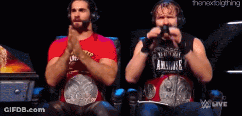Two Wrestlers Are Sitting Next To Each Other With Their Hands Folded . GIF