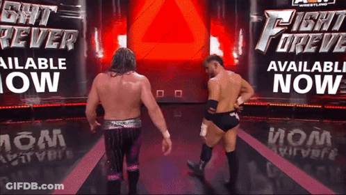 Two Wrestlers Are Standing In Front Of A Sign That Says Fight Forev Available Now GIF