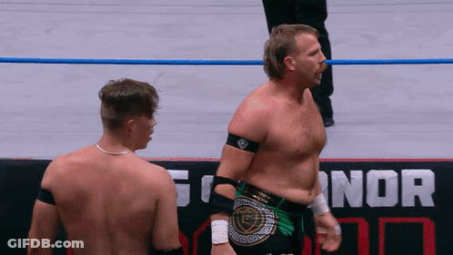 Two Wrestlers Are Standing In Front Of A Sign That Says Nor On It GIF