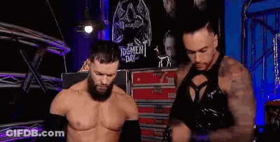 Two Wrestlers Are Standing Next To Each Other In A Ring . GIF