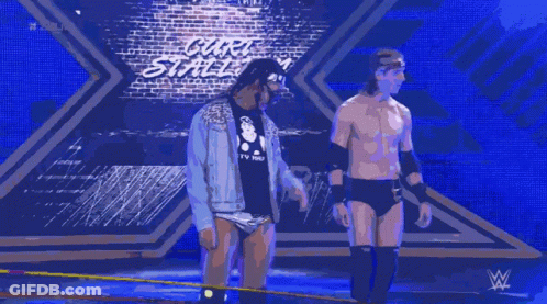 Two Wrestlers Are Standing On A Stage In Front Of A Sign That Says Carl 'S Street GIF