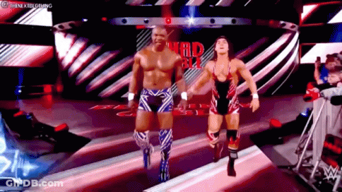 Two Wrestlers Are Walking Down A Ramp In A Wrestling Ring . GIF