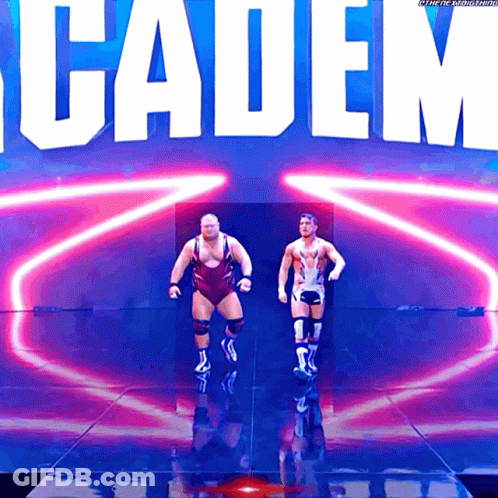 Two Wrestlers Are Walking On A Stage In Front Of A Sign That Says Cadem GIF