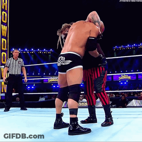 Two Wrestlers Are Wrestling In A Ring With A Sign That Says Super Showdown GIF