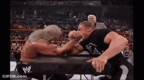 Two Wrestlers Arm Wrestling In A Ring GIF