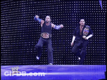 Two Wrestlers Dancing In Front Of W Wall GIF