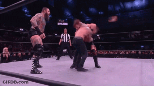 Two Wrestlers Fighting In Wrestling Ring With Referee GIF