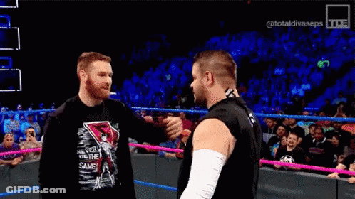 Two Wrestlers Hugging In Wrestling Ring GIF