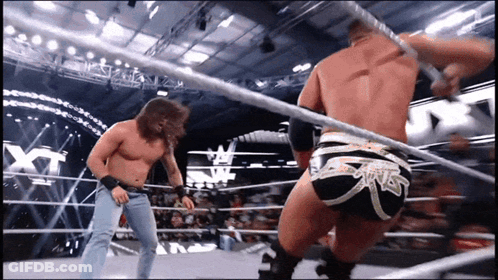 Two Wrestlers In A Ring Saying NXT GIF
