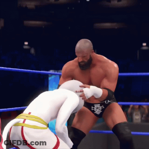 Two Wrestlers In A Ring With One Wearing A Belt That Says U. GIF