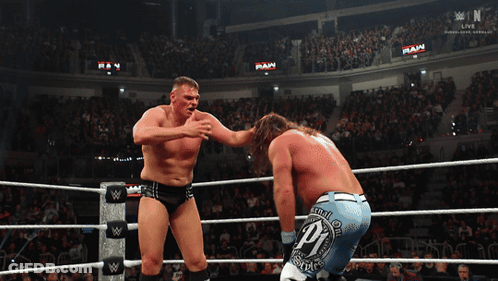 Two Wrestlers In A Ring With The Word Raw On The Wall GIF