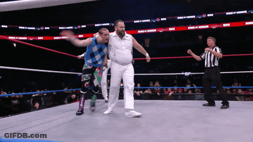 Two Wrestlers In A Ring With The Words King Of Honor On The Walls GIF
