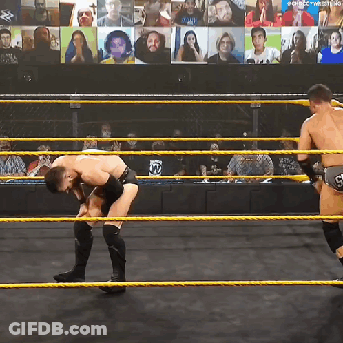 Two Wrestlers In A Wrestling Ring With A Screen Behind Them That Says ' Chicago Wrestling ' On It GIF
