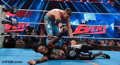 Two Wrestlers In A Wrestling Ring With A Sign That Says W GIF