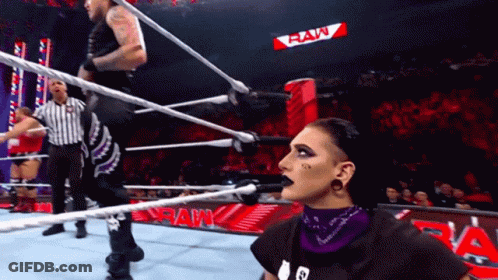 Two Wrestlers In Ring With Raw Sign GIF